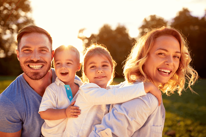 Family of 4 smiling during sunset